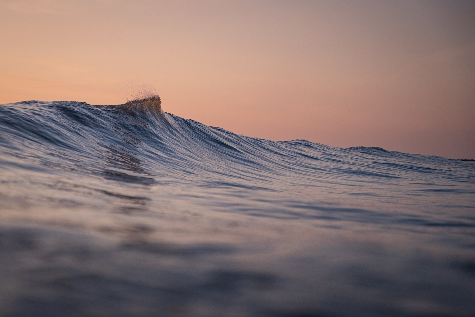 Weiche Welle vor pastellfarbenem Himmel bei Hvide Sande